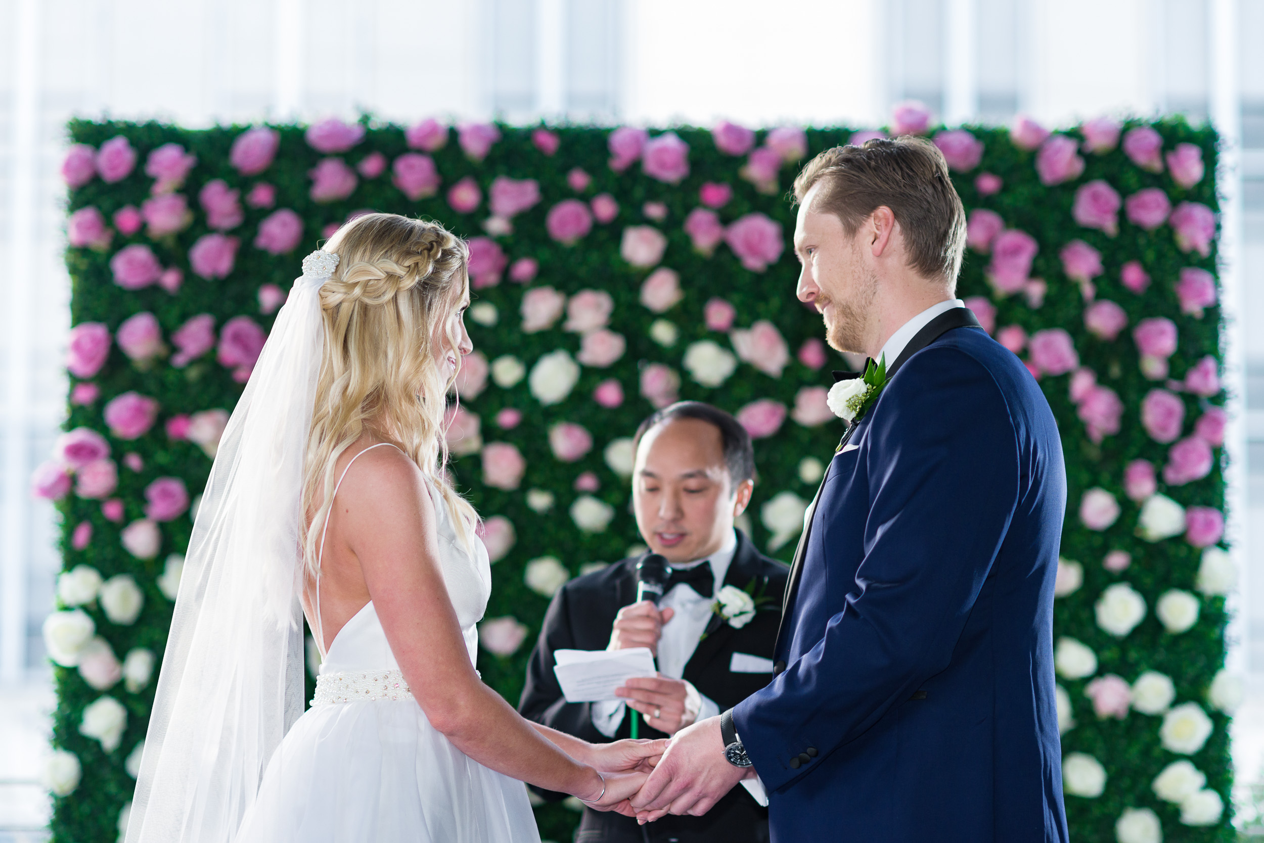 Austin-wedding-photographers-ceremony-brazos-hall-downtown-flower-backdrop-pink-roses